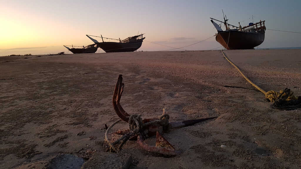 Dhows lie on dry land due to the low tide. South of Hilf, Masirah Island, Oman.